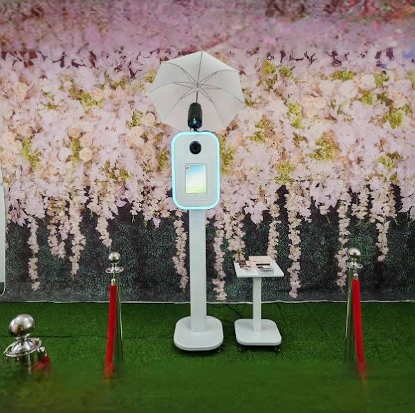 Photobooth installé devant un décor floral